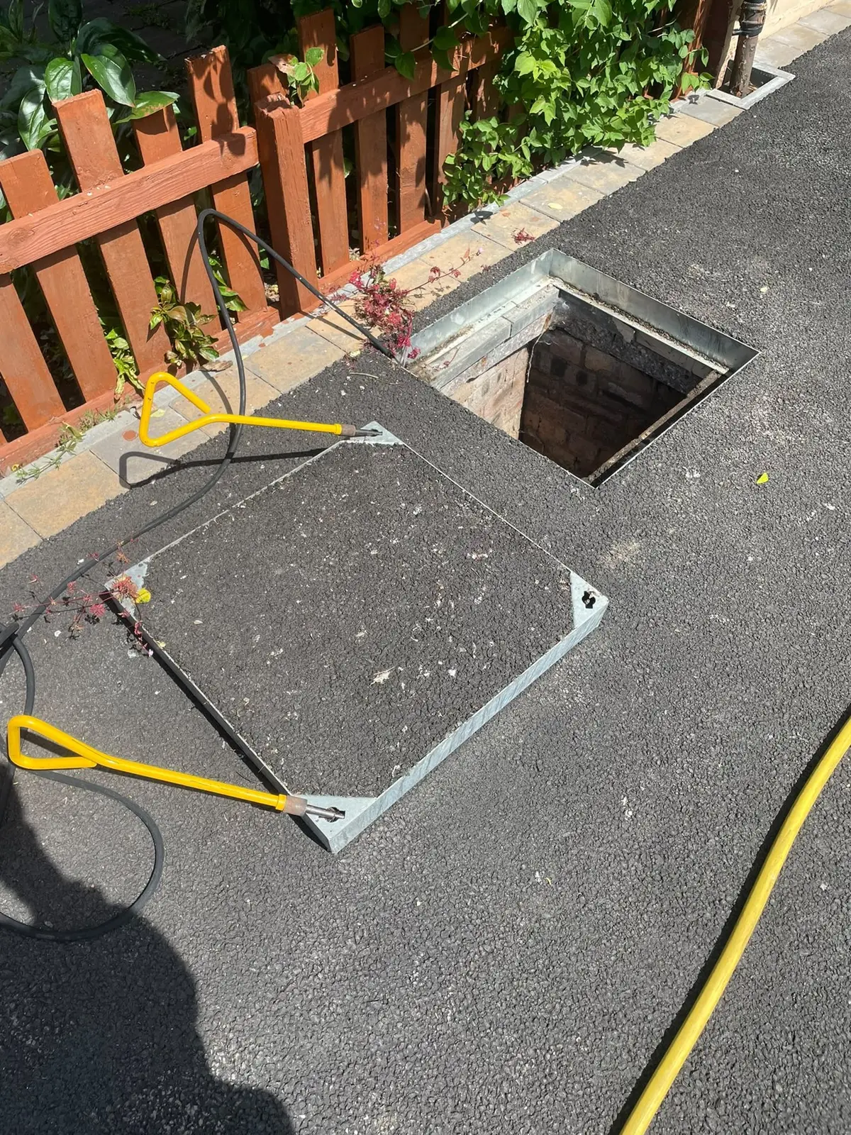 Inspection chamber opened on site, with the lifting keys and cover beside it