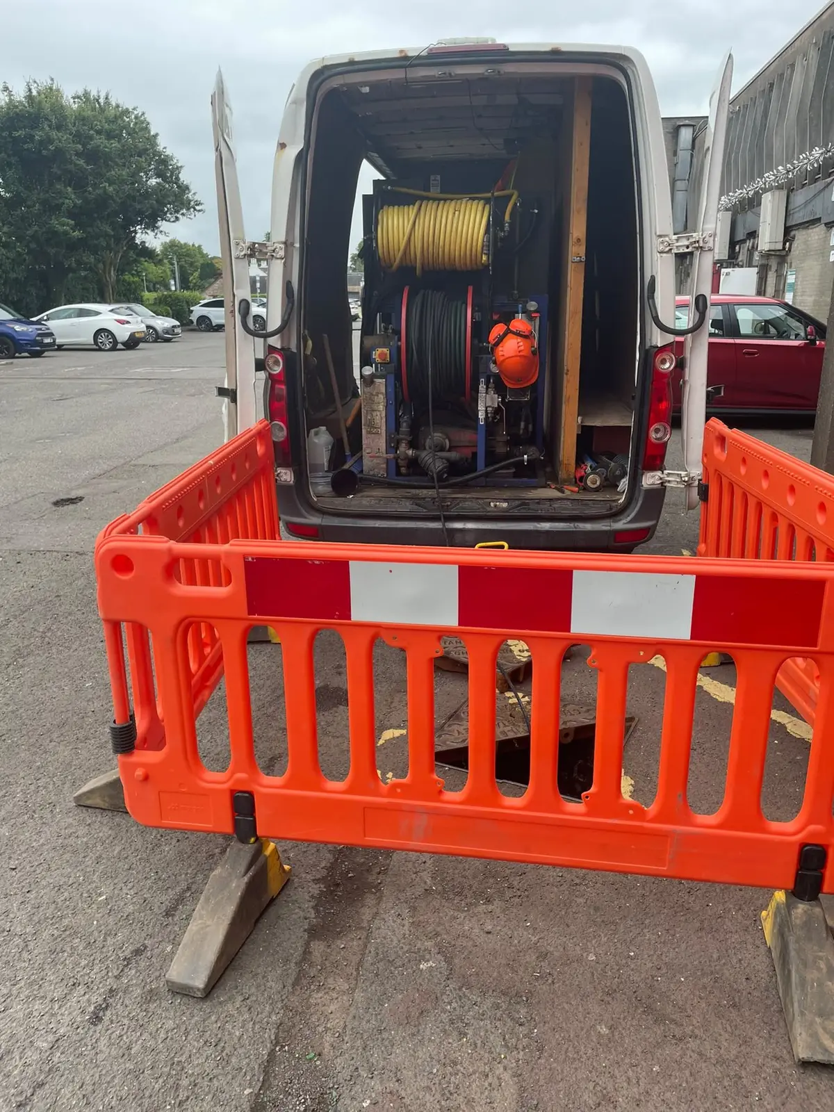 MCR Drainage Solutions van with the jetting unit, set up behind safety barriers over an open chamber